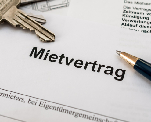 Mietvertrag mit Kugelschreiber und Schlüsseln im Hintergrund