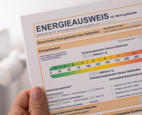 Hand hält einen Energieausweis hoch